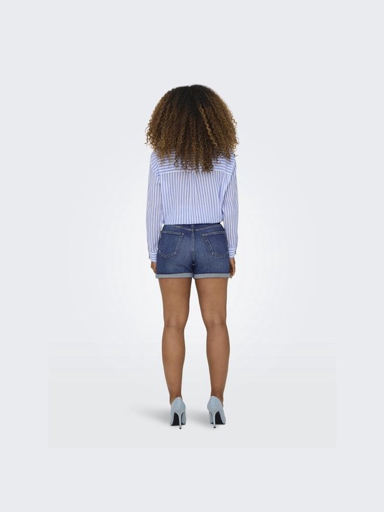 Achterkant van een vrouw in blauwgestreepte blouse en denim shorts met opgerolde zoom.