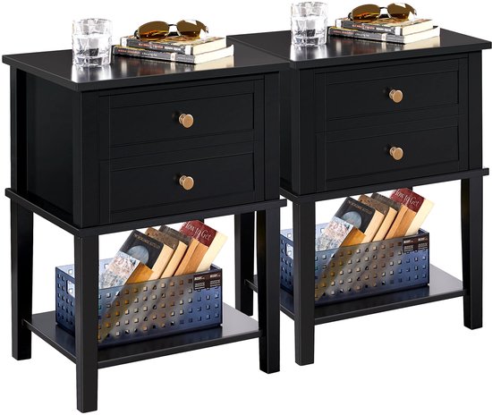Twee zwarte nachtkastjes met laden en legplanken, met boeken en decoratie. Naast banken.