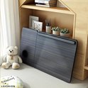 De grijze gestreepte laptoptafel is opgevouwen en staat op de grond naast een teddybeer.