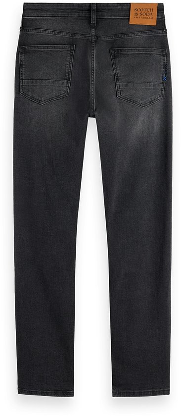 Achterkant van een donkergrijze jeans met leren merklabel.