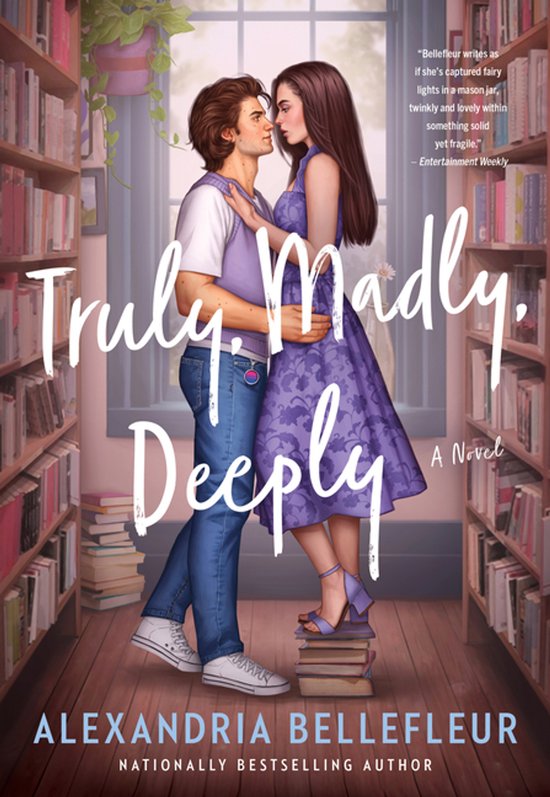 Boekcover: Man in paarse trui en jeans, vrouw in paarse jurk, omhelzen in bibliotheek. Titel: Truly. Madly. Deeply.