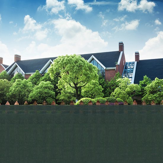 Donkergroen schaduwdoek als erfafscheiding voor een huis.