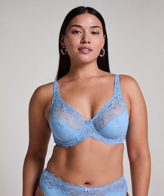 Model met lichtblauwe beugelbeha met bloemenbroderie en strikje op de cups.