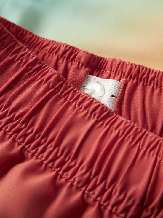 Rode zwembroek met elastische tailleband en knoopsluiting.
