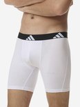 Zijkant van een witte Adidas boxer met zwarte tailleband met logo.