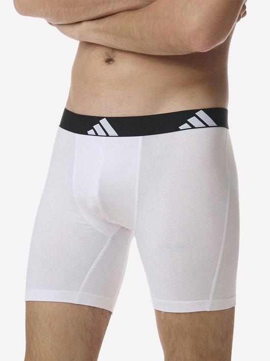 Zijkant van een witte Adidas boxer met zwarte tailleband met logo.