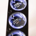 Close-up van een Shelly Power Strip 4 Gen4 stopcontact met blauwe LED-verlichting op een zwarte behuizing.
