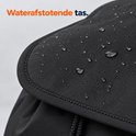 Close-up van de waterafstotende zwarte stof met regendruppels op de klep.