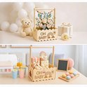 Bovenste afbeelding: houten krat met 'OH BABY' tekst, gevuld met bloemen, met teddybeer. Onderste afbeelding: cadeaus en macarons, met 'OH BABY' krat.