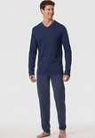 Man met lange mouwen marineblauw V-hals pyjamashirt en een pyjamabroek met een grafisch patroon in donkerblauw en lichtblauw.
