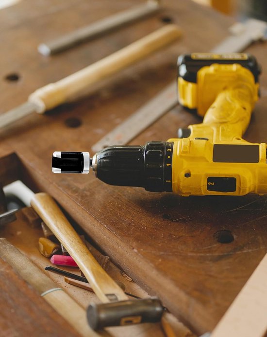 Gele boormachine met een plugsnijder, geplaatst in een werkbank met gereedschap.