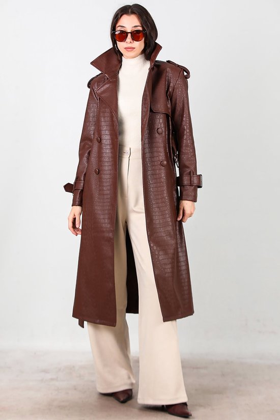 Lange bruine trenchcoat van imitatieleer met krokodillenmotief, open gedragen over een crème coltrui.