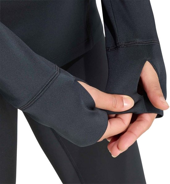 Gedetailleerde close-up van de duimgaten van het zwarte Adidas sportshirt voor dames.