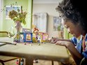 Enfant jouant avec le magasin de vêtements vintage LEGO Friends sur une table.