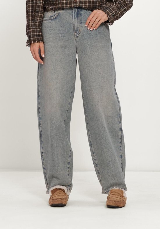 Lichtblauwe wijde jeans met hoge taille, gecombineerd met een bruin geruit overhemd en suède instappers.