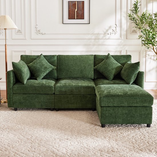 Groene chenille L-vorm bank met ottomaan, in een woonkamer.