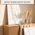 Twee witte kunstpanelen met 3D-structuur op een houten kast, naast een vaas met gedroogde grassen.