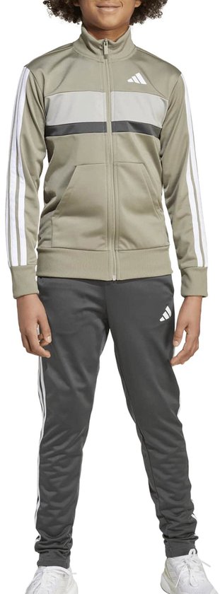 Model draagt een olijfgroen Adidas Tiberio trainingspak met witte 3-stripes en witte Adidas-logo's.