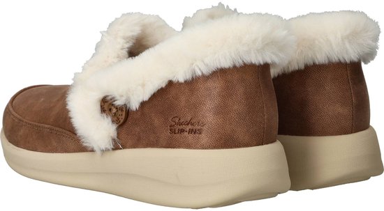 Achterkant van bruine Skechers dames sloffen met witte bontrand en beige zolen.