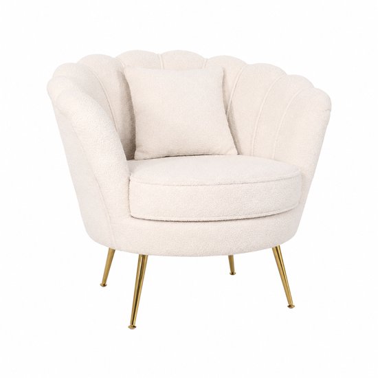 Fauteuil teddy couleur crème avec dossier en forme de coquillage, coussin d'assise rond, quatre pieds dorés et un petit coussin assorti.