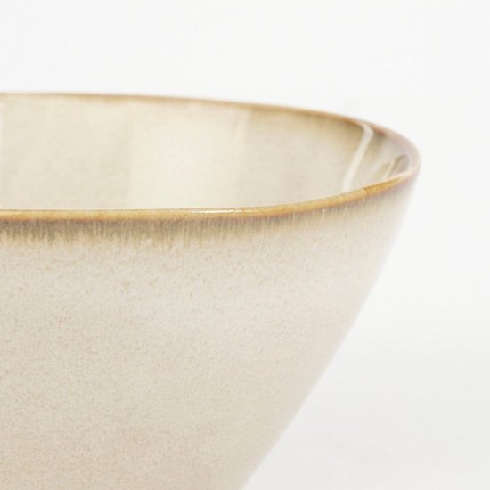 Detailopname van een beige stenen kom met een karakteristieke bruine rand.
