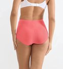 Achterkant van koraalkleurige maxi-slip, gedragen door een model.