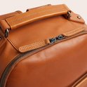 Bovenzijde van bruine lederen rugzak met handvat en ritsen met 'The Chesterfield Brand' merknaam.