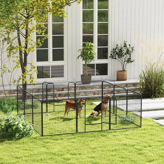 Zwarte speelpen voor honden op een groen gazon voor een wit huis, met twee honden binnenin.