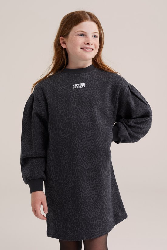 Meisje met rood haar, lachend, in donkergrijs oversized sweat jurkje met luipaardprint en pofmouwen.