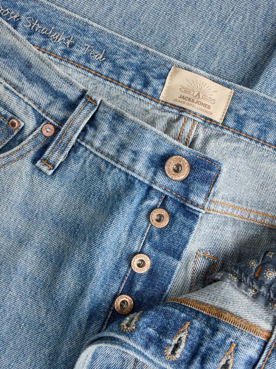 Detail van de knoopsluiting en label met 'Jack & Jones Jeans Intelligence' op een blauwe jeans.