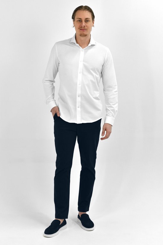 Man draagt een wit Vercate overhemd in slim fit met lange mouwen, gecombineerd met een donkere broek.