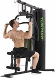 Man traint rug met de lat pulley van een Tunturi krachtstation.