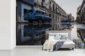 Behang - Fotobehang Vintage auto's weerspiegeld in plassen op in een straat Cuba - Breedte 330 cm x hoogte 220 cm