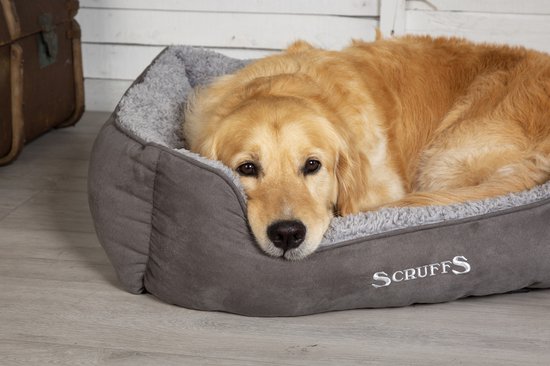 Grijze hondenmand met pluche voering, met een golden retriever erin.