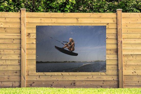 Une femme sportive s'agenouille sur un poster de jardin wakeboard 180x120 cm - Toile de jardin / Toile d'extérieur / Peintures d'extérieur (décoration de jardin) XXL / Groot format!