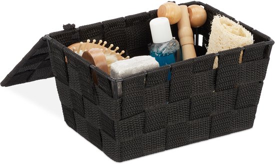 Panier tressé noir avec des accessoires de bain tels qu'un masseur et une éponge végétale.