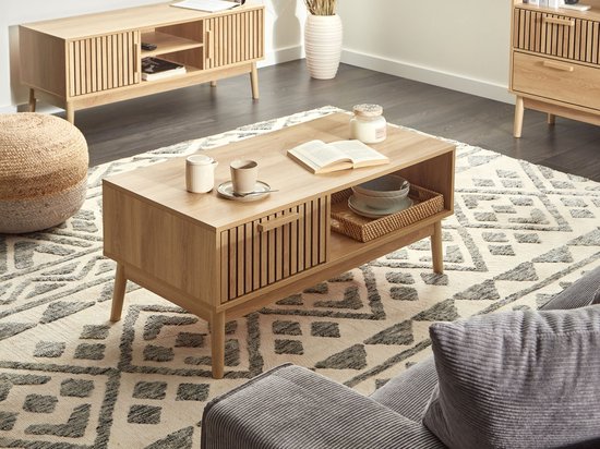 Woonkamer interieur met houten salontafel, bijzettafel en vloerkleed.