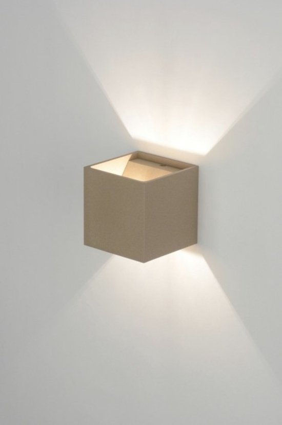 Taupekleurige kubusvormige wandlamp aan een witte muur, met de open bovenkant en licht dat naar boven en beneden schijnt.