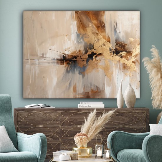Abstract doek met bruine en gouden accenten, hangend boven een kast in een woonkamer met blauwe stoelen.