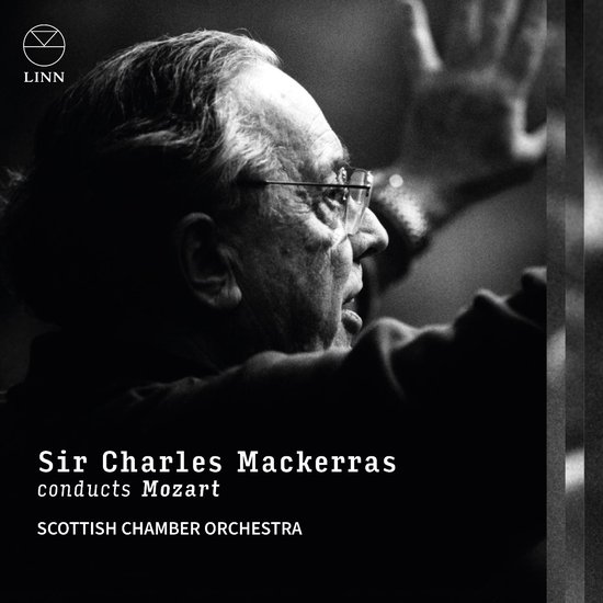 Portret van Sir Charles Mackerras met bril, regisserend. De tekst 'Sir Charles Mackerras conducts Mozart Scottish Chamber Orchestra' staat onderaan.