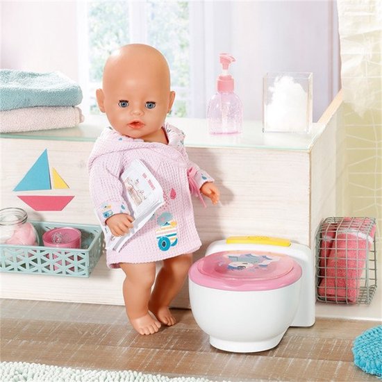 BABY born pop in roze badjas met krantje bij het potje.