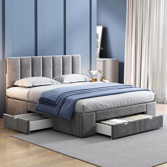Grijze gestoffeerde bedombouw met opgemaakt bed en uitgeschoven lades, in een slaapkamer.