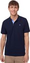 Model draagt een marineblauw poloshirt met korte mouwen en een lichte blauwe kraag. Hij draagt een beige broek.