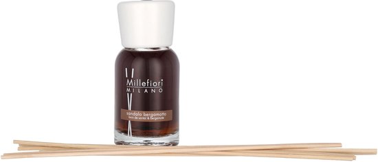 Bruine glazen fles diffuser met witte dop en stokjes, naast een stapel dunne houten stokjes.