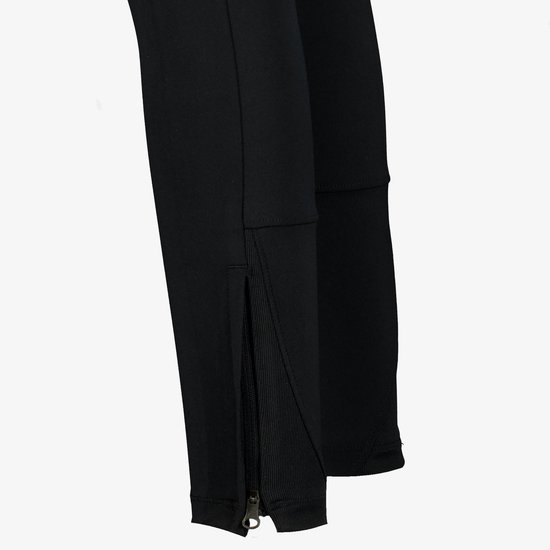 Sluiting van de rits aan de onderkant van een zwarte Nike trainingsbroek.