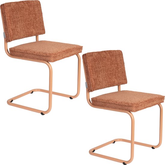 Twee oranje eetkamerstoelen met teddy-stof bekleding en lichtbruine metalen frames, naast elkaar.