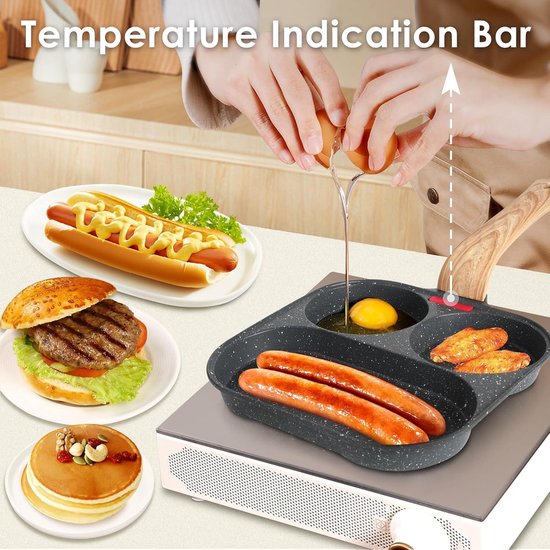 Grijze pan met 3 vakken op een kookplaat, met worstjes, ei, kipvleugels, hotdog, hamburger, pannenkoeken.