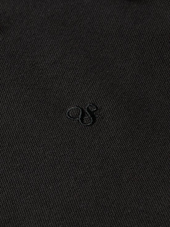 Detail van een zwart poloshirt met geborduurd logo.