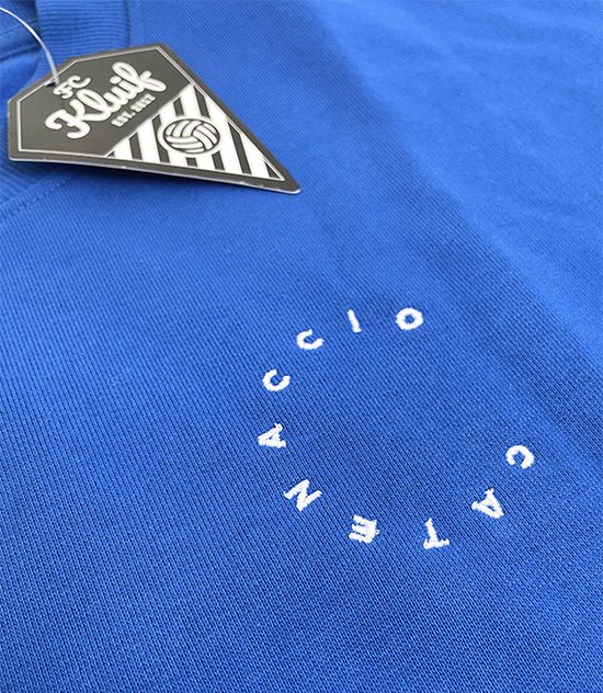Detail van blauwe sweater: neklabel FC Kluif, witte tekst in cirkel op borst.