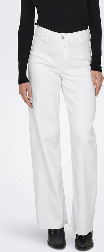 Model van voren in wijde witte jeans met rafelige zoom en zwarte laarzen.
